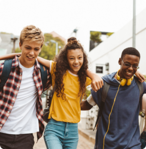 three young people link arms and smile