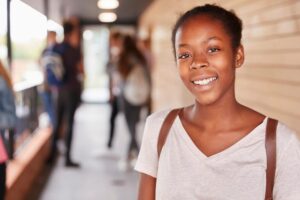 a young person smiles at the camera outside with friends after getting help for anxiety