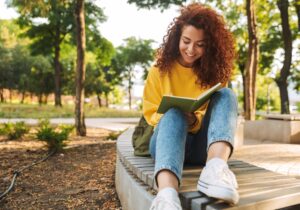 a young person sits outside and journals for mental health treatment