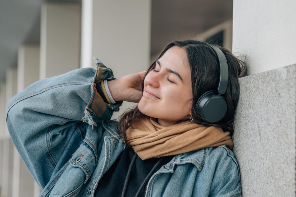 young person listening to music on headphones after learning about music therapy and mental health