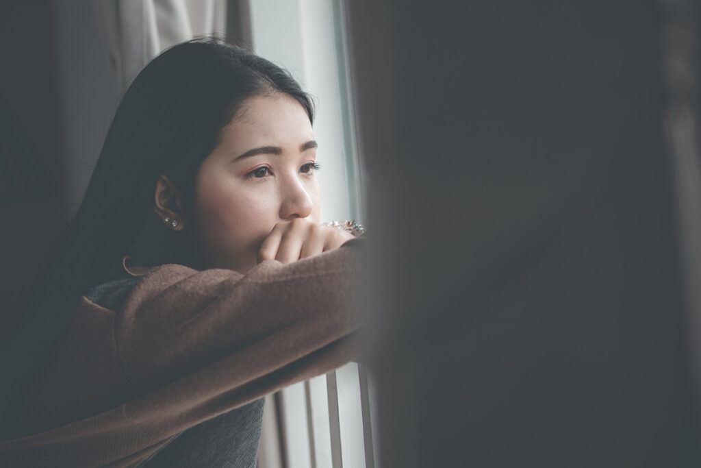 young person looking out window contemplating adolescent depression prevention